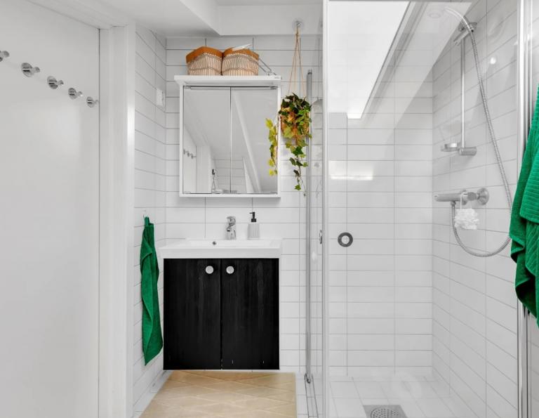 Vegghengt servantskap med ett-greps armatur. Vegghengt speilskap med overbelysning. Dusjhjørne med innfellbare glassdører.